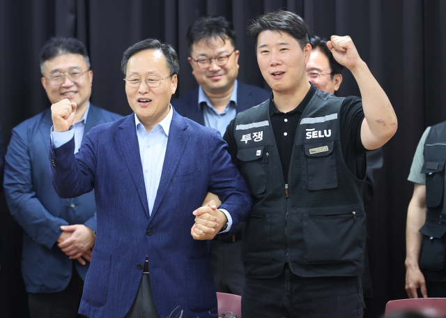 20일 경기도 수원시 장안구 경기고용노동청에서 열린 삼성전자 임금협상을 마친 후 여명구 삼성전자 DS(디바이스솔루션·반도체 사업 담당) 피플팀장과 최승호 삼성그룹 초기업노동조합 삼성전자지부 위원장이 잠정 합의안에 서명한 후 파이팅을 외치고 있다. 연합뉴스