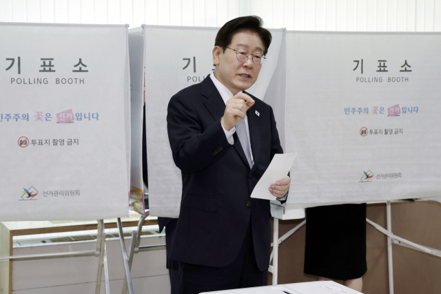 이재명 대통령이 제9회 전국동시지방선거 사전투표 첫날인 29일 서울 종로구 삼청동 주민센터에서 사전 투표 중 기표 도장 관련 문의를 하고 있다. 연합뉴스