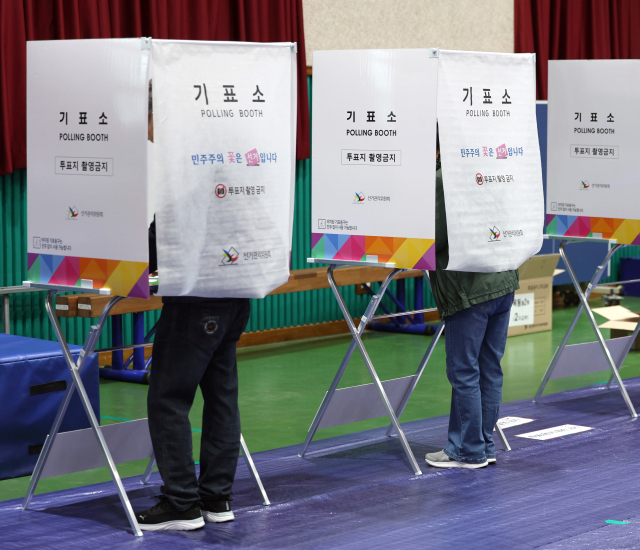 6·3 지방선거 및 국회의원 재·보궐선거 본 투표일인 3일 오전 울산 남구 격동초등학교에 마련된 옥동제2투표소 내 기표소에서 유권자들이 소중한 한 표를 행사하고 있다. 연합뉴스