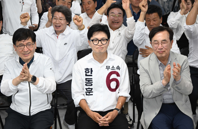 부산 북갑 국회의원 보궐선거에 출마한 하정우 더불어민주당 후보의 선거사무실 관계자와 지지자들이 3일 부산 북구 선거사무실에서 지상파 방송 3사 출구조사 결과에 환호하고 있다(왼쪽). 무소속 한동훈 후보는 이날 부산 북구 선거사무소에서 방송사 출구조사 결과를 지켜봤다. 김종진 기자 kjj1761@
