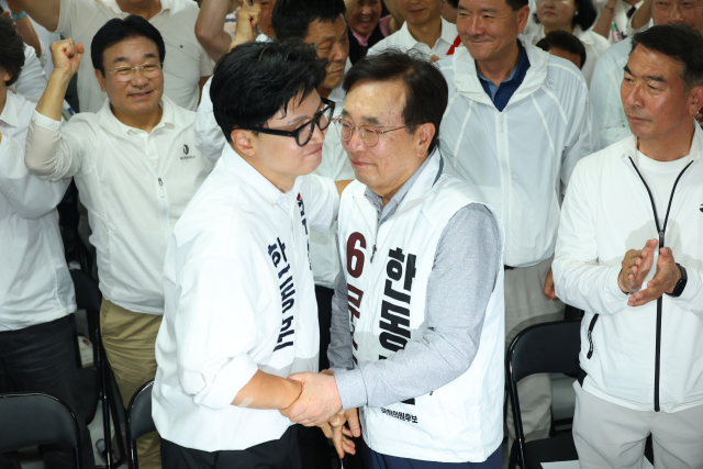 무소속 한동훈 부산 북갑 국회의원 보궐선거 후보가 4일 부산 북구 선거사무소에서 선거방송을 시청하기 위해 입장해 서병수 명예선대위원장과 포옹하고 있다. 연합뉴스