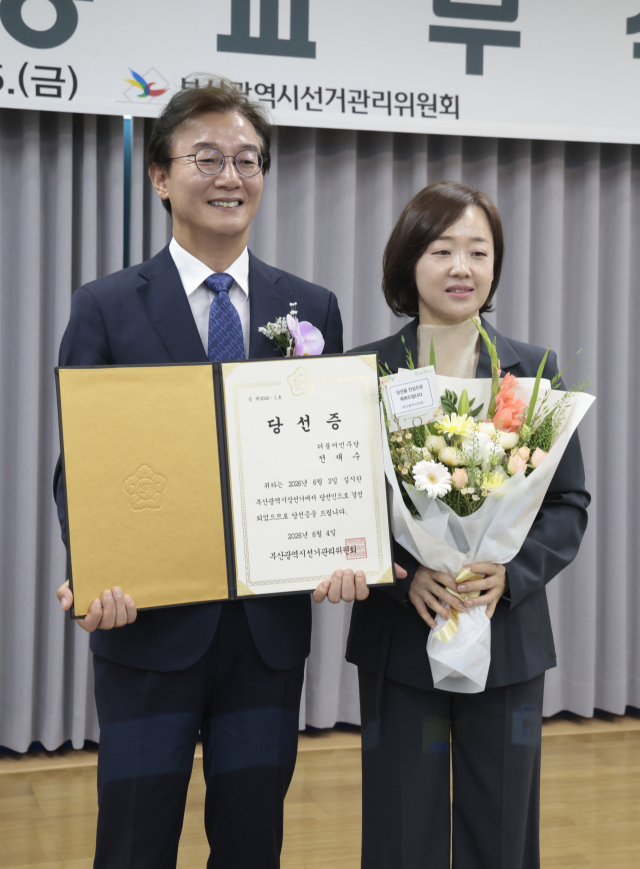 전재수 부산시장 당선인이 지난 5일 부산시선관위에서 열린 당선증 교부식에서 배우자 최혜진 씨와 함께 기념촬영을 하고 있다. jhyun@