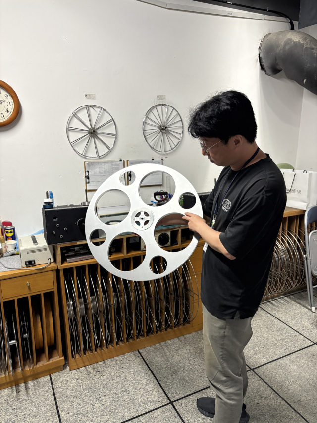 김대철 영사기사가 16mm 릴을 들고 설명하고 있다. 김준현 기자 joon@