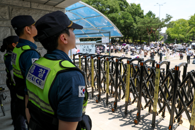 6·3 지방선거 투표용지 부족 사태를 규탄하며 재선거를 요구하는 '잠실 개표소 봉쇄 시위'가 계속되고 있는 9일 서울 송파구 올림픽공원 핸드볼경기장 출입구 앞에서 경찰들이 서 있다. 연합뉴스