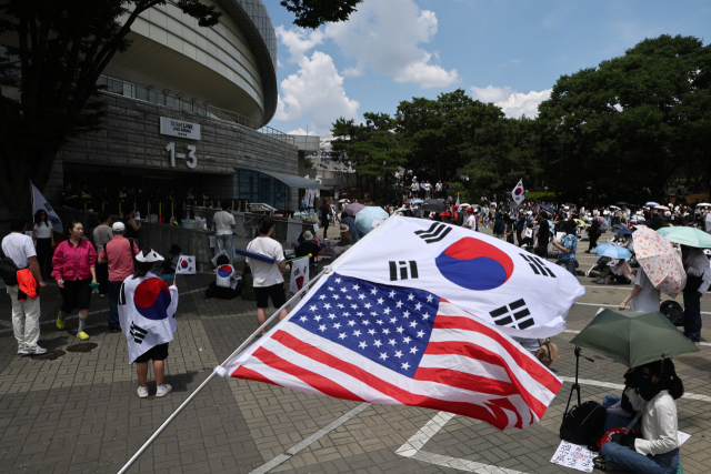 6·3 지방선거 투표용지 부족 사태를 규탄하며 재선거를 요구하는 '잠실 개표소 봉쇄 시위'가 계속되고 있는 8일 서울 송파구 올림픽공원 핸드볼경기장 출입구 앞에서 참가자들이 구호를 외치고 있다. 연합뉴스