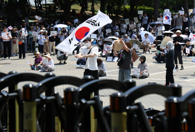 6·3 지방선거 투표용지 부족 사태를 규탄하며 재선거를 요구하는 '잠실 개표소 봉쇄 시위'가 계속되고 있는 9일 서울 송파구 올림픽공원 핸드볼경기장에서 시민들이 구호를 외치고 있다. 연합뉴스
