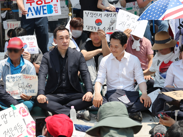 6·3 지방선거 투표용지 부족 사태로 촉발된 잠실 개표소 봉쇄 시위가 이어진 16일 국민의힘 장동혁 대표, 김민수 최고위원이 서울 송파구 올림픽공원 핸드볼경기장 개표소 앞에 자리를 잡고 앉아 있다. 연합뉴스