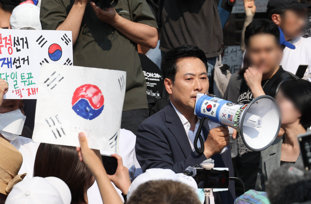 6·3지방선거 투표용지 부족 사태로 촉발된 잠실 개표소 봉쇄 시위가 이어진 16일 국민의힘 장동혁 대표가 서울 송파구 올림픽공원 핸드볼경기장 2-1 출입구로 진입을 시도했지만 시민 한 명이 문을 가로막아 진입하지 못하고 체육단체 직원들을 돌려 보냈다고 시민들에게 알리고 있다. 연합뉴스