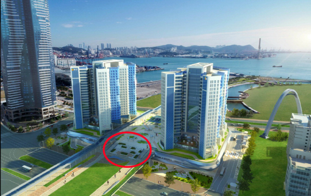 부산항만공사(BPA)가 '지구단위계획 위반'을 이유로 부산항 북항 환승센터 사업시행자인 피큐건설에 토지매매계약 해제를 통보했다. 부산역과 북항 친수공원을 연결하는 북항 환승센터 공사 현장(위)과 환승센터(C-1블록) 조감도. 빨간색 동그라미 부분이 공공보행통로 단차 3.3m 발생 구간이다. 정종회 기자 jjh@·부산항만공사 제공