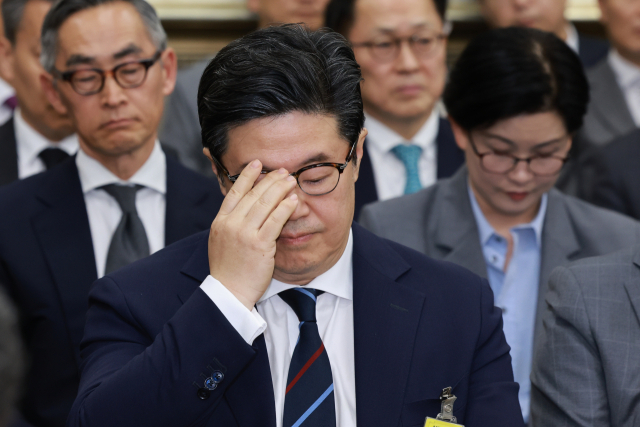 MBK파트너스 김병주 회장이 지난해 서울 여의도 국회에서 정무위원회 국정감사에 증인으로 출석해 안경을 만지고 있다. 연합뉴스
