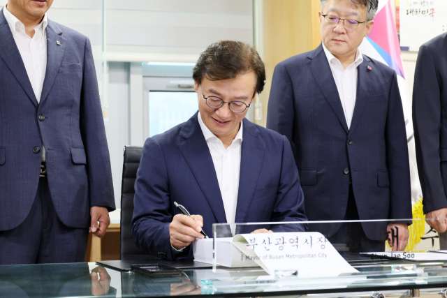 전재수 부산시장이 1일 부산 연제구 부산시청 집무실에서 인계인수서에 서명하고 있다. 연합뉴스