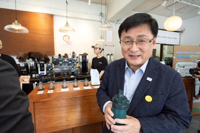 김성환 기후에너지환경부 장관이 3일 서울 영등포구 한 카페에서 사장, 시민단체 및 시민들과 함께 자원순환 실천 캠페인을 마치고 텀블러를 이용해 커피를 구입하고 있다. 연합뉴스