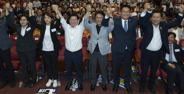 12일 국회 의원회관에서 열린 전국자치분권민주지도자회의(KLDC)에 더불어민주당 당 대표 후보 주자들과 자치분권회의 상임대표인 박승원 광명시장이 손을 들어 인사하고 있다. 정청래 전 대표, 송영길 의원, 김민석 전 총리, 박승원 광명시장, 고민정 의원, 김보미 전 강진군 의원. 연합뉴스