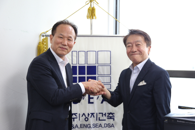 지난 13일 상지건축 본사에서 <부산일보>와 인터뷰를 가진 오철호(왼쪽) 대표이사 회장과 허동윤 전임 회장이 손을 맞잡고 신구(新舊)의 조화로운 동행을 약속하며 기념 촬영을 하고 있다. 상지건축 제공