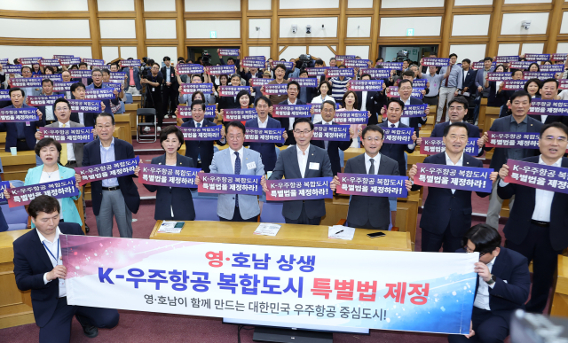 더불어민주당 문금주 의원과 국민의힘 서천호 의원이 15일 국회 의원회관에서 공동 주최한 '영·호남 우주항공 상생동맹 K-우주항공, 복합도시건설 특별법 제정 토론회'에서 더불어민주당 한병도 대표 직무대행을 비롯한 여야 의원들이 함께 특별법 제정을 촉구하고 있다. 연합뉴스