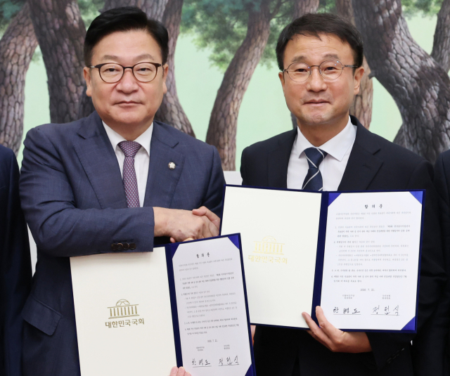 더불어민주당 한병도(오른쪽) 대표 직무대행 겸 원내대표와 국민의힘 정점식 원내대표가 21일 국회 운영위원장실에서 선관위 투표용지 부족 사태에 따른 특검법안 합의문에 서명한 뒤 악수하며 기념 촬영을 하고 있다. 연합뉴스