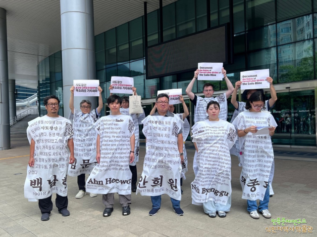민족문제연구소와 연구소 부설 식민지역사박물관, 일제강제동원시민모임 등 시민단체 회원들이 21일 유네스코 세계유산위원회가 열리고 있는 부산 벡스코 회의장 인근에서 강제 동원 조선인 탄광 노동자들의 이름이 적힌 대자보를 입고 퍼포먼스를 하고 있다. 연합뉴스