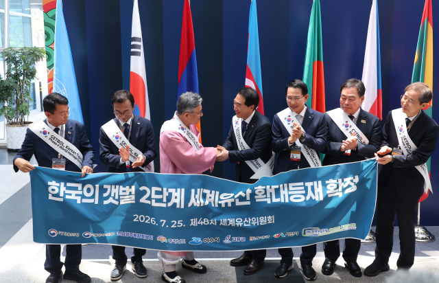 25일 부산 해운대구 벡스코에서 열린 제48차 유네스코 세계유산위원회 본회의에서 ‘한국의 갯벌’ 2단계 등재가 확정되자 허민 국가유산청장과 박수현 충남도지사를 비롯한 갯벌이 위치한 지역 단체장들이 축하 현수막을 들고 있다. 연합뉴스