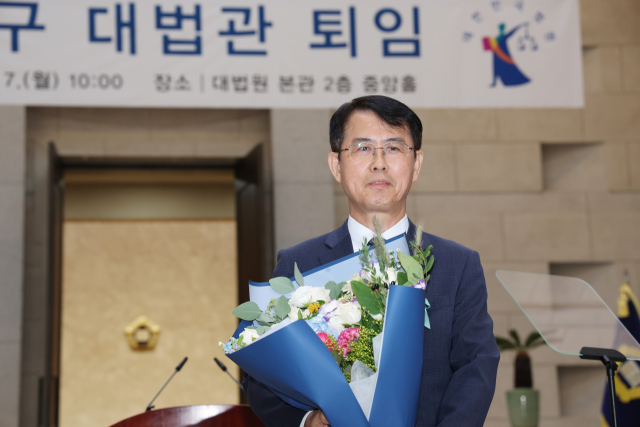 이흥구 대법관이 7일 서울 서초구 대법원에서 열린 퇴임 행사에서 꽃다발을 들고 있다. 연합뉴스