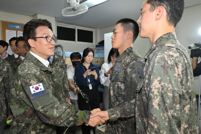 더불어민주당 김민석 대표가 23일 경기도 김포 인근의 공군 8542부대를 방문해 전입 신병들과 악수하고 있다. 연합뉴스