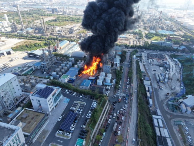 14일 오전 울산 울주군 온산읍 부승화학 공장 화재 현장에서 소방당국이 저장탱크 사이로 번진 불길을 잡기 위해 진화 작업을 벌이고 있다. 공장 바닥이 소방대가 뿌린 거품 소화약제로 하얗게 덮여 있다. 독자 제공