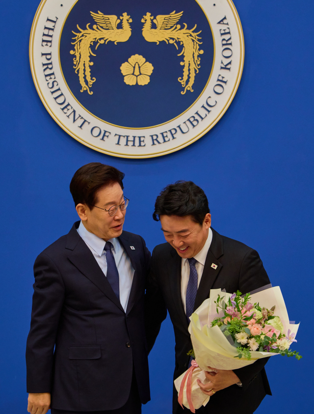 이재명 대통령이 15일 청와대에서 강훈식 전 비서실장에게 공로패를 전달한 뒤 포옹하고 있다. 연합뉴스