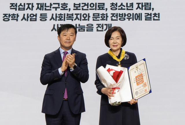 리움미술관 홍라희(오른쪽) 명예관장이 26일 서울 중구 우리은행 본점에서 열린 대한적십자사 창립 기념식에서 보건복지부 이형훈 제2차관으로부터 국민훈장 동백장을 수여받은 뒤 포즈를 취하고 있다.삼성문화재단 제공