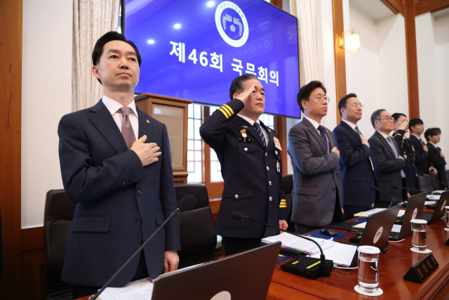 김지용 중대범죄수사청장과 김종철 경찰청장 직무대행 등이 27일 이재명 대통령 주재로 청와대에서 열린 국무회의에서 국기에 경례하고 있다. 연합뉴스
