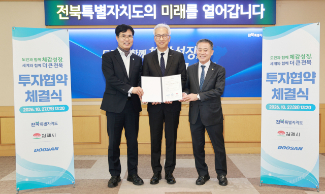 김인욱 두산 전자BG장(왼쪽 둘째)이 이원택 전북특별자치도지사(왼쪽 첫째), 정성주 김제시장과 광모듈용 ccl 전용 생산라인 구축을 위한 투자협약을 체결한 후 기념사진을 촬영하고 있다. 두산 제공